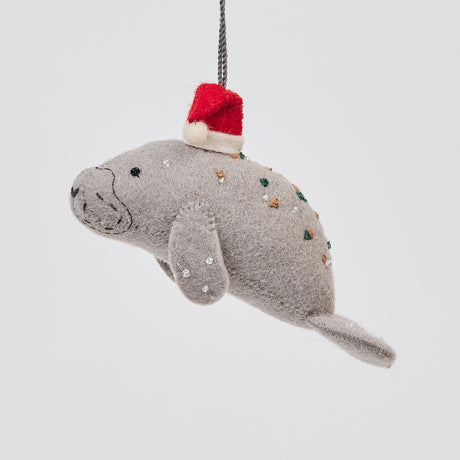 Handmade felt Santa Manatee ornament from Craftspring, featuring a red Santa hat and intricate beaded and embroidered details—heirloom-quality Christmas decor, ethically crafted by artisans using sustainable wool.