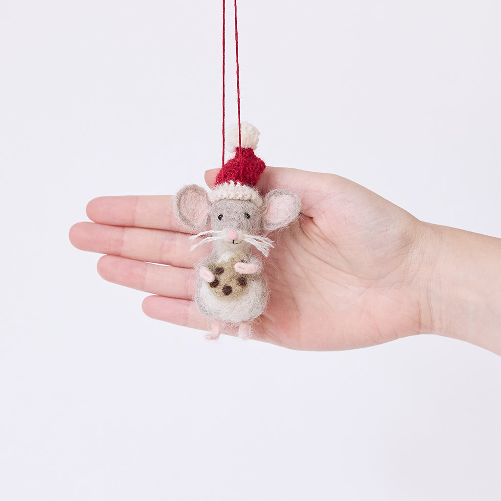 Craftspring’s Santa Mouse with Cookie Ornament displayed in front of a hand to show its size — needle felted mouse with a cute face and whiskers, wearing a knitted Santa hat and holding a cookie, a charming heirloom-quality piece for Christmas gifting — ethically crafted by artisans using sustainable wool.