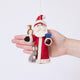 Craftspring’s Santa with Woodland Animals ornament held in front of a hand to show its size—handmade from sustainable wool with a Santa holding beaded birdseed, a bunny next to him, and an owl and bluebird perched on his arms, ethically crafted by artisans using sustainable wool.