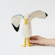 Let your holiday décor take flight with our handcrafted Seagull Tree Topper, a whimsical coastal alternative to the traditional star or angel. With wings fully outstretched, bright yellow legs, and classic black-tipped feathers, this charming seabird captures the freedom and beauty of life by the ocean.