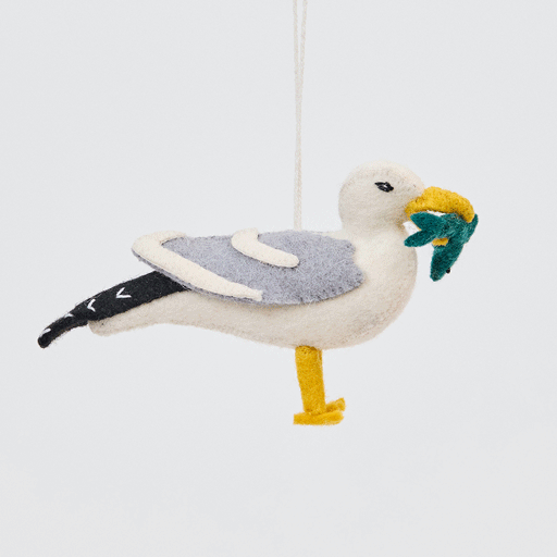 Handmade felt Seagull ornament from Craftspring rotating to show front, side, and back views—highlighting embroidered details and the fish in its beak, sustainably handmade by artisans using wool.