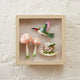 Handcrafted garden-themed shadow box with felt ornaments and cream fabric background