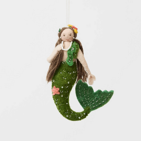 Add a touch of ocean magic to your Christmas tree with our beautiful Siren Mermaid Ornament. Lovingly handcrafted from eco-friendly wool felt, this elegant mermaid features flowing brunette hair, a vibrant green tail adorned with sparkling bead accents, and charming floral details inspired by the treasures of the sea.