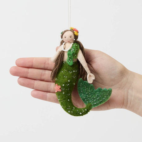 Add a touch of ocean magic to your Christmas tree with our beautiful Siren Mermaid Ornament. Lovingly handcrafted from eco-friendly wool felt, this elegant mermaid features flowing brunette hair, a vibrant green tail adorned with sparkling bead accents, and charming floral details inspired by the treasures of the sea.