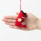 Handcrafted in vibrant red wool felt, this charming little ski boot ornament features soft gray buckles, a delicate white edelweiss flower with sunny yellow beaded details, and a touch of alpine nostalgia.