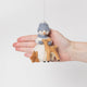Craftspring’s Snowman with Friends Ornament from the Tender Woodland Ornaments Bundle displayed in front of hand to show its size — felt snowman with friends, featuring a sweet and tender expression with intricate beaded and embroidered details, a charming heirloom-quality piece for Christmas gifting — ethically crafted by artisans using sustainable wool.
