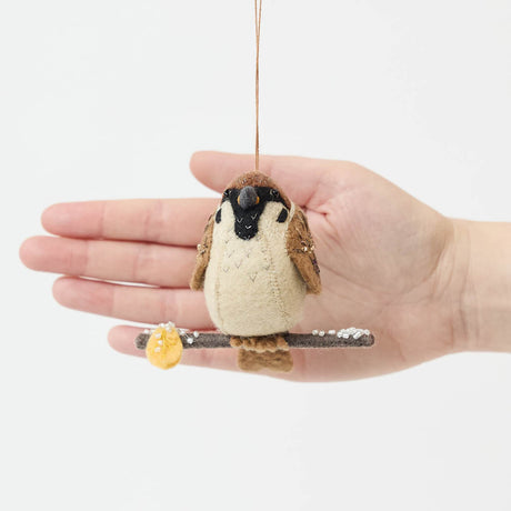 Celebrate the quiet beauty of everyday birds with our Sparrow Ornament. Small yet full of personality, this beloved garden bird is lovingly hand-felted from natural wool and perched on a delicate felt branch.