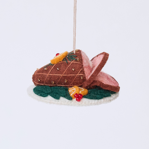 Handmade felt Spiral Ham Platter ornament from Craftspring rotating to show front, side, and back views—featuring intricate beaded and embroidered details on a festive ham, ethically crafted by artisans using sustainable wool.