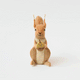 Our Squirrel Tree Topper is a handmade wool felt Christmas decoration featuring a beautifully embroidered bushy tail and golden beaded acorn, designed to perch atop your holiday tree or stand on its own as whimsical woodland décor.