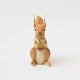 Our Squirrel Tree Topper is a handmade wool felt Christmas decoration featuring a beautifully embroidered bushy tail and golden beaded acorn, designed to perch atop your holiday tree or stand on its own as whimsical woodland décor.