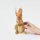 Our Squirrel Tree Topper is a handmade wool felt Christmas decoration featuring a beautifully embroidered bushy tail and golden beaded acorn, designed to perch atop your holiday tree or stand on its own as whimsical woodland décor.