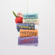 Handmade felt ornament featuring a miniature stack of colorful books, meticulously crafted from natural wool using traditional felting techniques. This eco-friendly and lightweight ornament adds a cozy, literary touch to holiday trees, bookshelves, or reading nooks. A charming gift for bookworms, teachers, and students, perfect for any occasion or year-round decor.