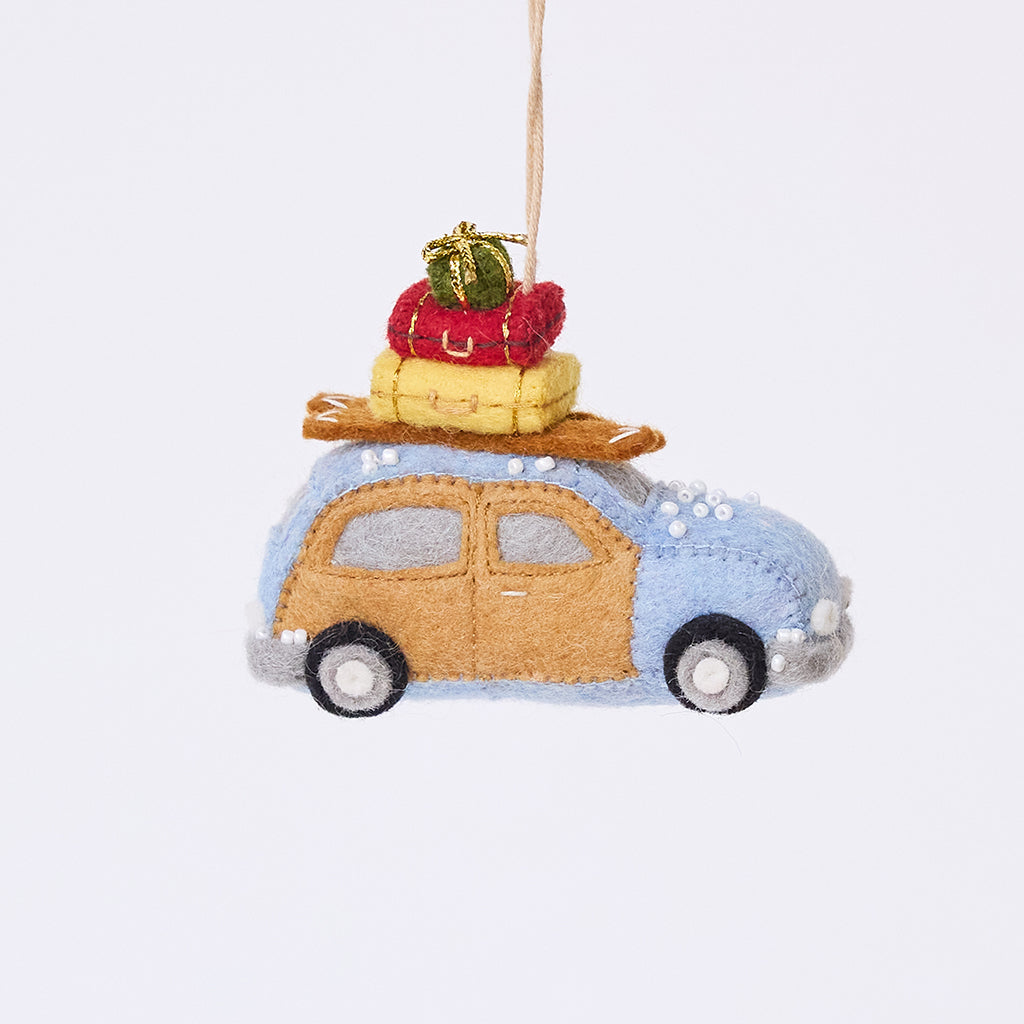 Craftspring’s Station Wagon with Luggage Ornament — felt blue station wagon carrying suitcases, skis, and presents on top, with beaded snow details — heirloom-quality Christmas ornament, perfect for holiday gifting, ethically crafted by artisans using sustainable wool.