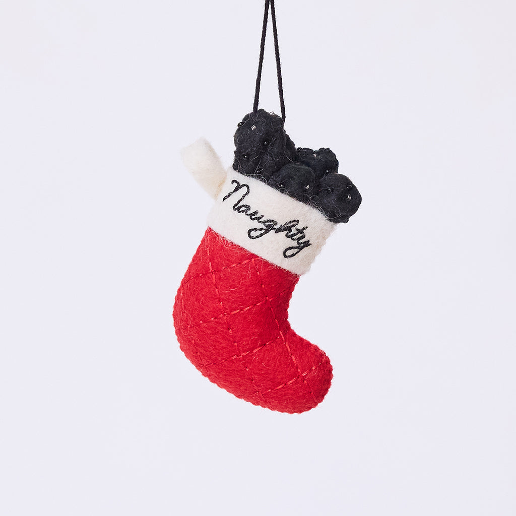 Craftspring’s Naughty Stocking with Coal Ornament — felt classic red stocking filled with felt coal and beads, featuring the embroidered word “naughty” — heirloom-quality Christmas ornament, perfect for holiday gifting, ethically crafted by artisans using sustainable wool.