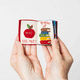 Handmade felt Strand Bookstore Book ornament from Craftspring shown flipping through interior pages—featuring intricate beaded and embroidered details inspired by the iconic bookstore, ethically crafted by artisans using sustainable wool.