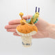 Hand-felted wool ornament of the Caterpillar from Alice in Wonderland, perched on a red-and-white mushroom with a hookah beside him. Features detailed embroidery and the phrase 'Who are you?' stitched at the base. Made from natural merino-blend wool, this whimsical ornament includes a hanging string and measures approximately 5.5 inches tall.