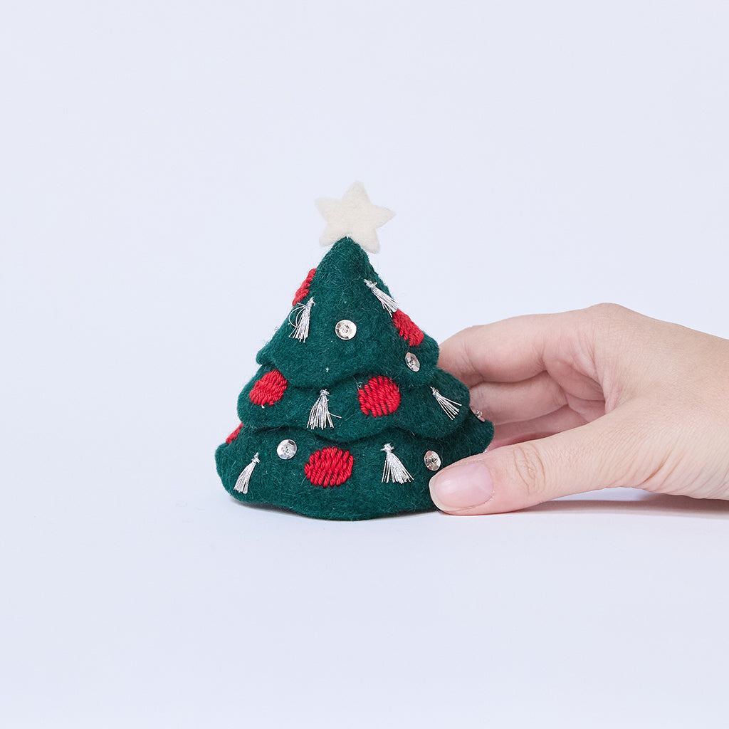 Craftspring’s Tinsel Tree held in hand to show its size — felt tree with silver tinsel tassels, embroidered baubles, beaded ornaments, and a star on top, a charming heirloom-quality holiday piece — ethically crafted by artisans using sustainable wool.