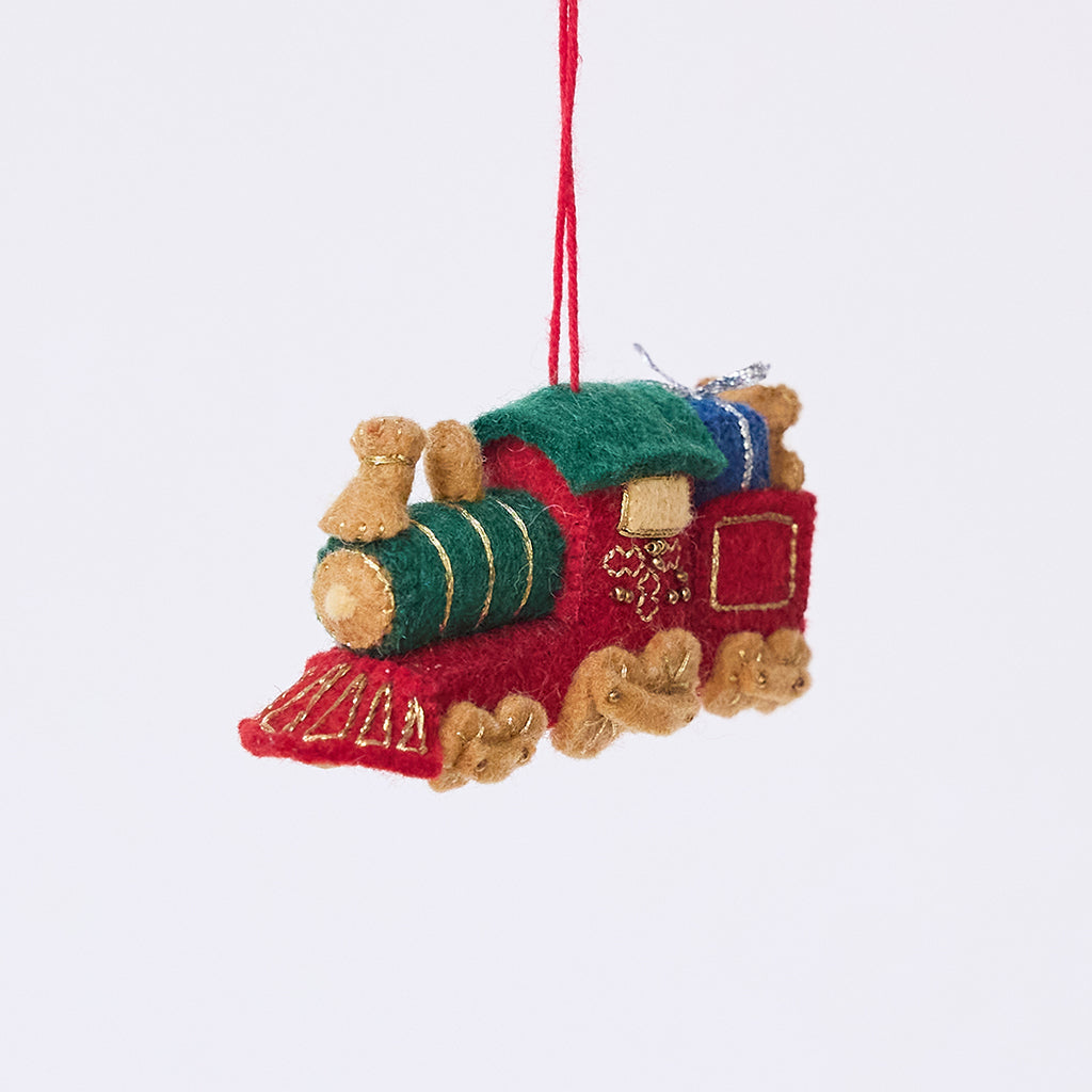 Craftspring’s Toy Train Ornament — felt red and green train with gold embroidery, intricately detailed with a team engine carrying presents and a teddy bear — heirloom-quality Christmas ornament, perfect for holiday gifting, ethically crafted by artisans using sustainable wool.