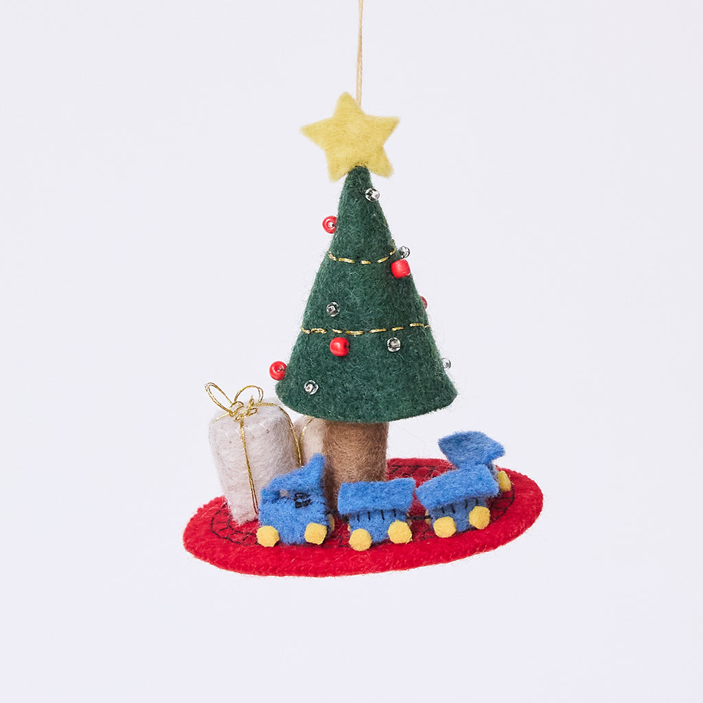 Craftspring’s Train Around the Christmas Tree Ornament — felt blue toy train wrapping around the base of a decorated Christmas tree with presents — heirloom-quality Christmas ornament, perfect for holiday gifting, ethically crafted by artisans using sustainable wool.