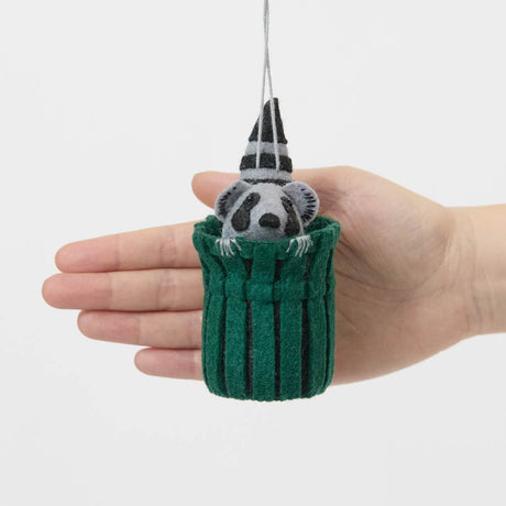 Every city has its unofficial mascot, and New York's just might be the mischievous raccoon. Meet our Trash Raccoon Ornament, peeking curiously from inside a classic green city trash can with the sweetest little face you've ever seen. Don't worry—this tiny trash panda is all charm and absolutely no trouble.