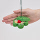 Handmade felt Turtle Sandbox ornament from Craftspring held in front of a hand to show its size—with the turtle shell cover slightly open revealing beaded sand, a bucket, mini shovel, and starfish inside, ethically crafted by artisans in India using sustainable wool.