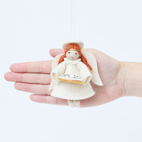 Craftspring’s Vintage-Style Angel Singing Noel Ornament displayed in front of a hand to show its size—handmade felt angel with intricate beaded and embroidered details, heirloom-quality Christmas ornament, perfect for holiday gifting, ethically crafted by artisans using sustainable wool.