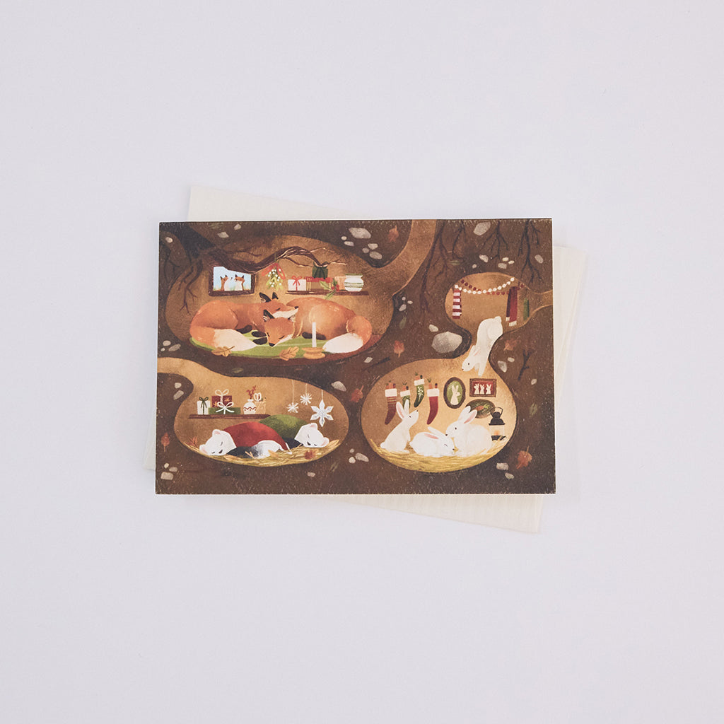 Handmade Woodland Burrows Greeting Card from Craftspring, featuring an illustration of woodland animals nestled in cozy holiday burrows—ethically printed in the USA on natural textured paper, perfect for sharing holiday cheer and gifting.