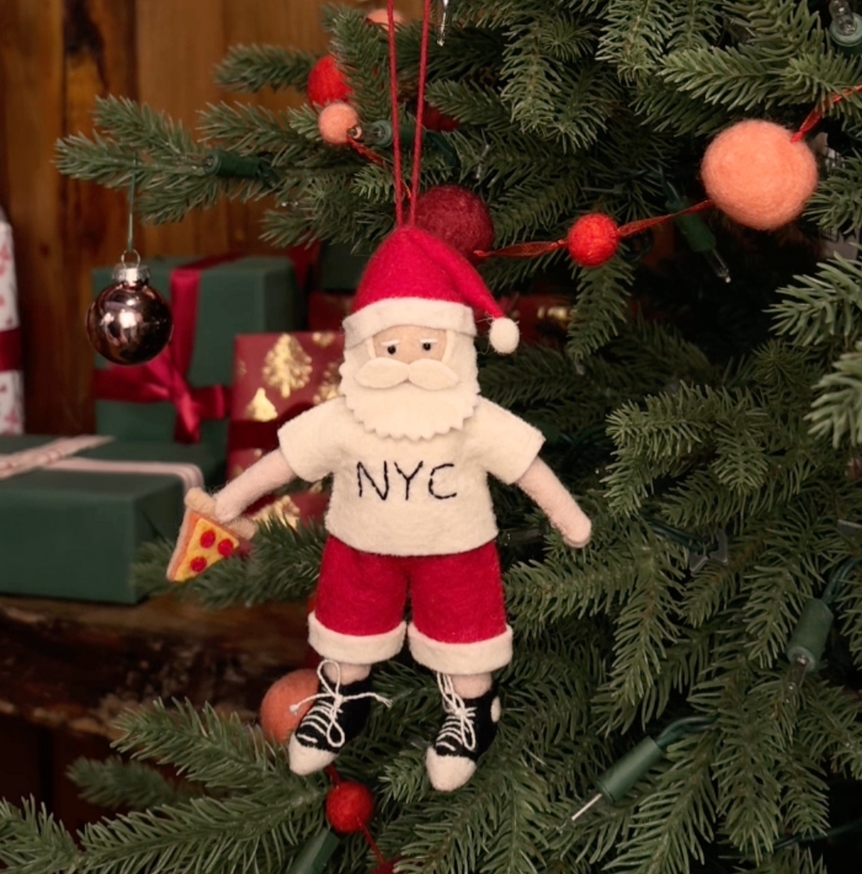 Celebrate Christmas in the Big Apple with our handmade NYC Santa Ornament, featuring Santa dressed like a true New Yorker with an NYC tee and a classic slice of New York pizza.

Who says Santa only runs on milk and cookies? After a busy night delivering gifts across the five boroughs, he's treating himself to a well-earned slice of New York pizza.