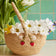 Hand-crocheted raffia basket with embroidered strawberry vines and blossom, eco-friendly spring decor.