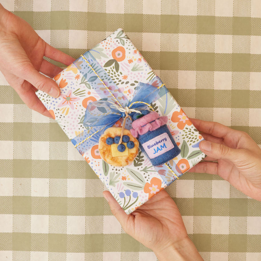 Felt pancake stack ornament topped with hand-felted blueberries and a yellow butter square.Hanging from a wrapped present along with a felt blueberry jam ornament.  Handmade from natural wool felt using needle-felting. Fair trade and ready to hang.