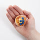 Felt pancake stack ornament topped with hand-felted blueberries and a yellow butter square. Handmade from natural wool felt using needle-felting. Fair trade and ready to hang. Held in a hand for scale.