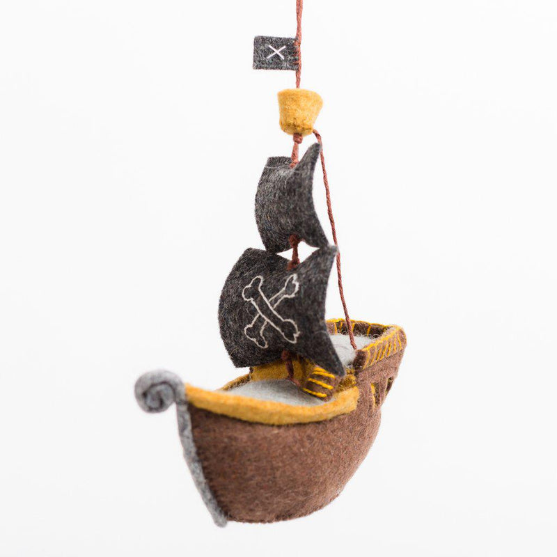 A handmade felt pirate ship ornament with a brown hull and black sails.