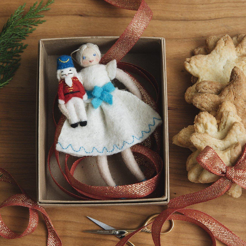 A Craftspring handmade felt Clara and nutcracker ornament Clara wearing white dress holding her small nutcracker doll
