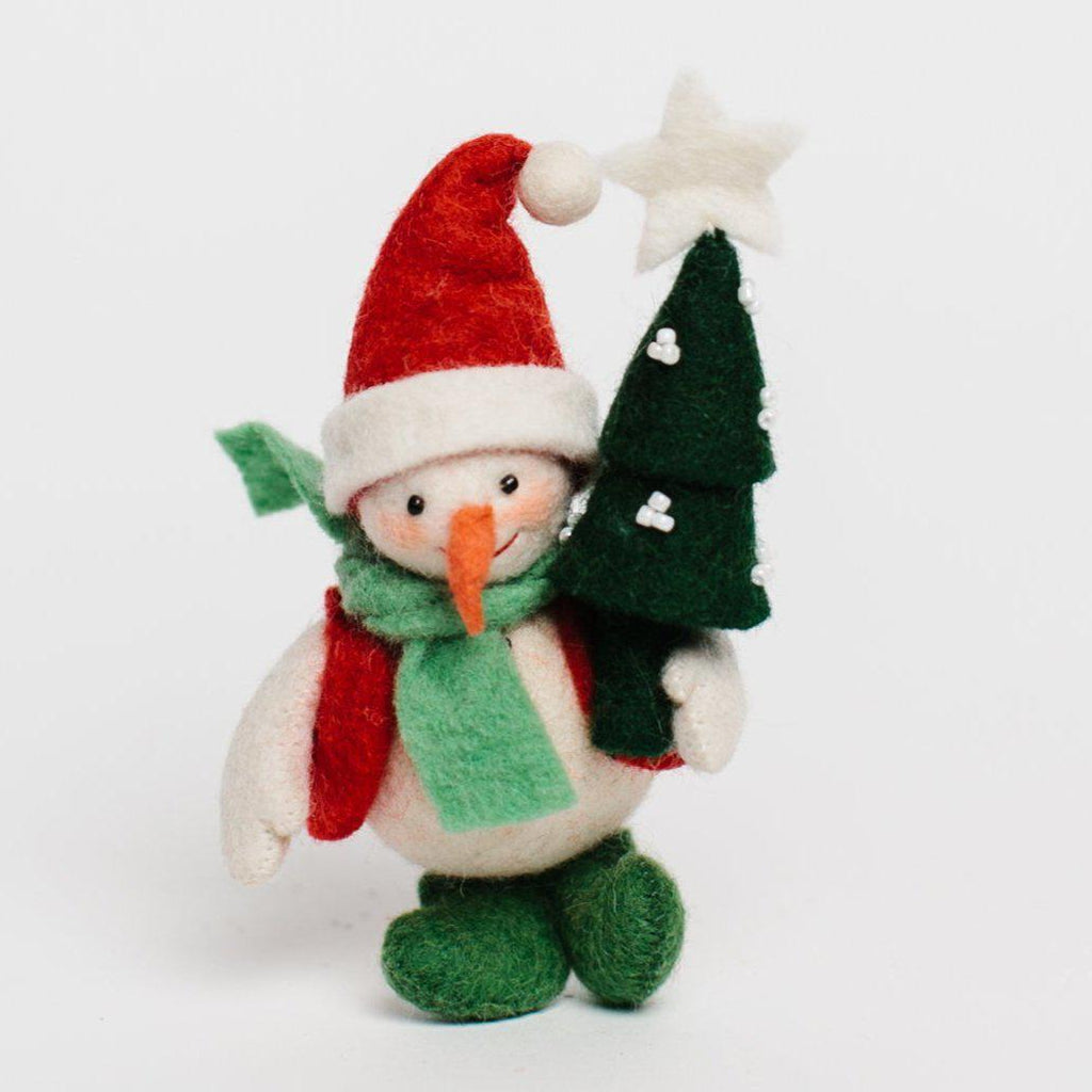 A Craftspring handmade felt snowman ornament with a santa hat, red vest green scarf and boots and holding a small christmas tree