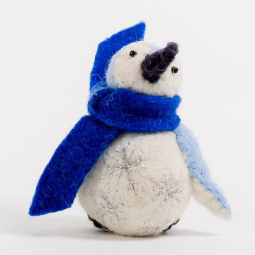 A Craftspring handmade felt penguin ornament with embroidered silver snowflake on their tummy and wearing a blue scarf