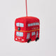 Felt ornament of a red London tour bus with holiday details, perfect for Christmas décor or travel-themed gifting. Handmade from wool felt. Fair trade and ready to hang