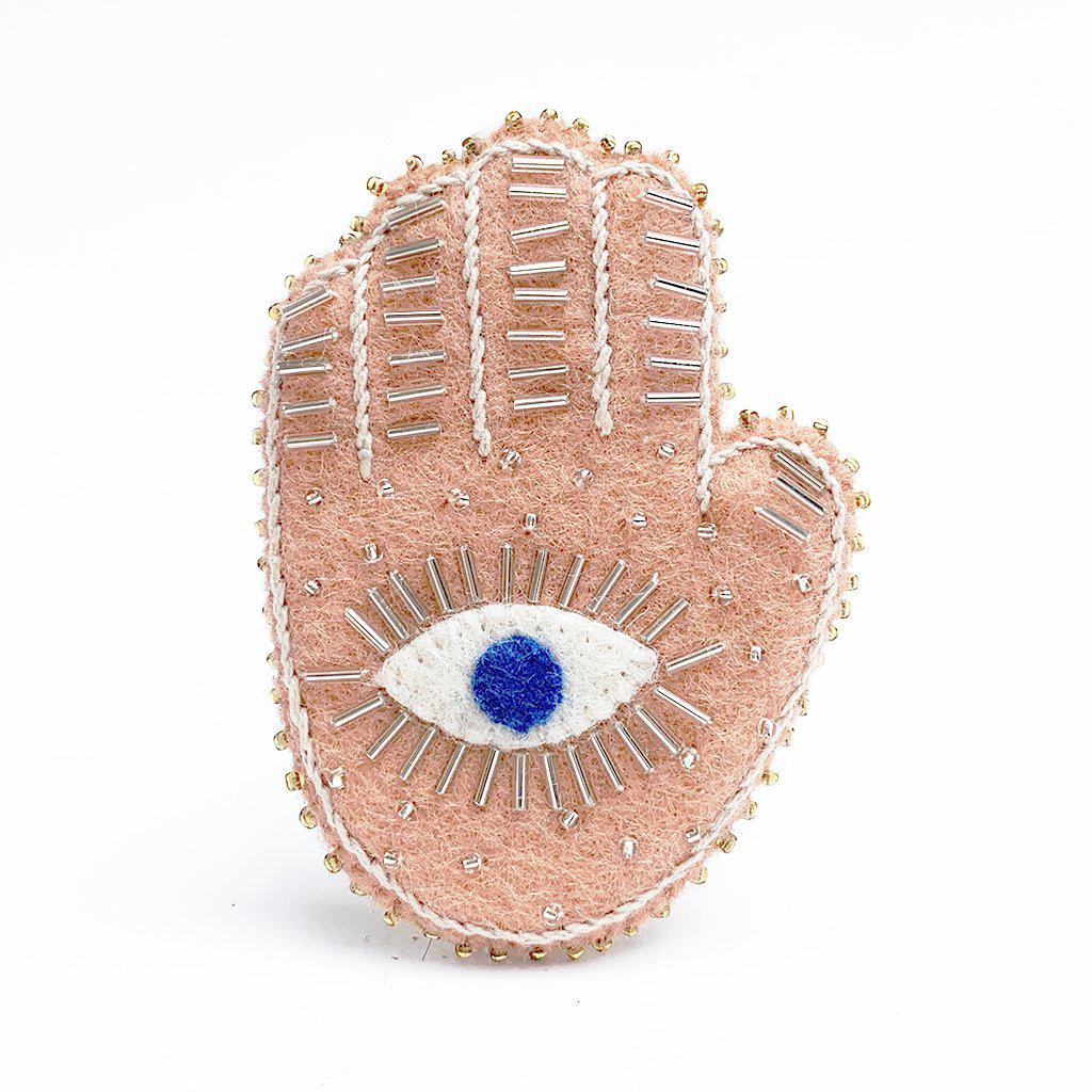 A Craftspring handmade felt pink hamsa ornament with a blue eye and white beading details