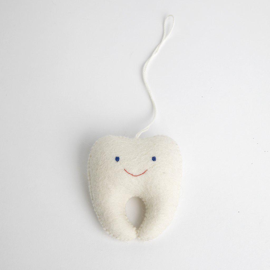 A Craftspring handmade felt tooth ornament with a small pocket on the back