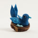Fair trade felt Mama Bluebird ornament hanging from a botanical tree – spring-inspired handmade decor.
