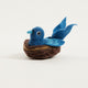 Soft wool felt bluebird nesting in a cozy handmade nest – perfect spring decoration symbolizing new beginnings.