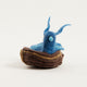 Hand-felted Mama Bluebird ornament warming eggs in a wool nest – spring decor inspired by nature and motherhood.