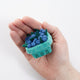 Felt blueberry pint ornament with hand-felted blue berries in a soft green wool basket. Handmade from natural wool felt using traditional needle-felting. Fair trade and ready to hang. In a hand for scale