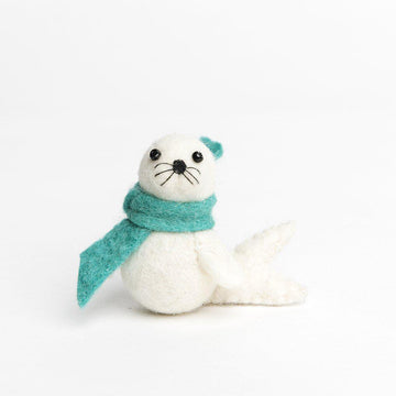 A Craftspring handmade white felt seal pup ornament wearing a green scarf