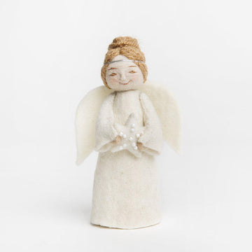 A Craftspring handmade felt angel ornament with blond hair up in a bun wearing white robes a silver circlet and holding a white beaded star