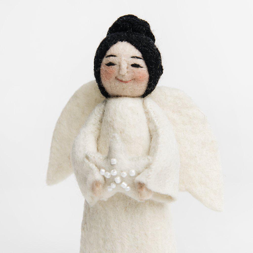 A Craftspring handmade felt angel ornament with black hair up in a bun wearing white robes and holding a beaded white star