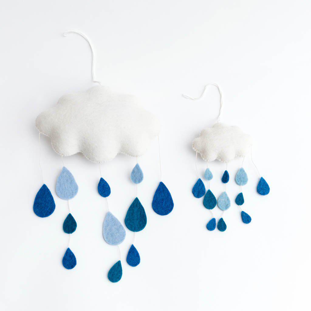 Natural wool spring cloud wall decor with stitched raindrops and budding florals, ideal for calming nursery or playroom display.